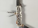 a knife with a corkscrew on it and a corkscrew in the middle