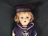 a doll that is wearing a sailor ' s outfit and hat