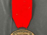a close up of a medal with a red ribbon on it