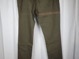 a pair of olive green pants hanging on a white curtain