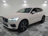 un SUV Volvo blanc garé sur un sol en carrelage à damier