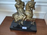 a statue of a man riding a horse on a wooden table