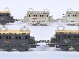 six petits trains posés sur une surface blanche