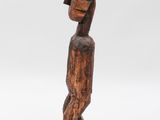 an image of a wooden sculpture of a man with a backpack on his back