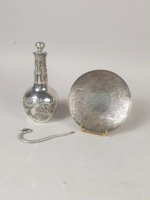 un plateau en argent et un vase en argent posés sur une table
