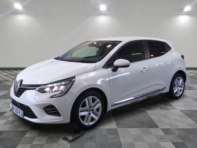 une voiture blanche est garée dans une grande pièce au sol en damier
