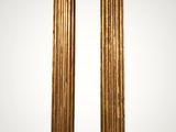 a pair of antique brass columns on a white background