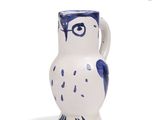 a blue and white owl shaped vase on a white surface