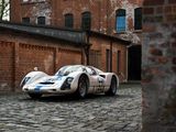 a white and blue race car parked in front of a brick building