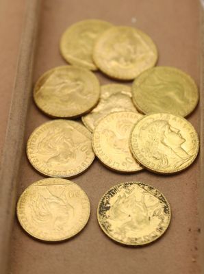 beaucoup de pièces d'or dans une boîte posée sur la table