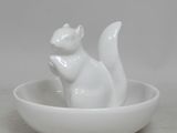 une figurine de chat blanc dans un bol posé sur une table