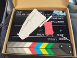 a box that has a movie clap and a knife in it