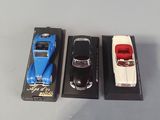 three toy cars sitting on a table next to each other
