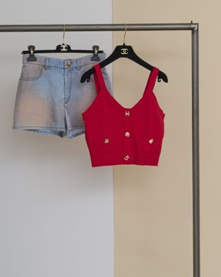 un ensemble composé d'un crop top rouge et d'un short en jean suspendu à un porte-vêtements