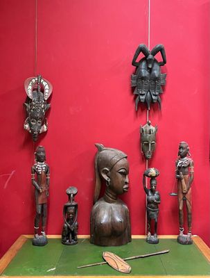 de nombreuses statues en bois exposées dans une pièce rouge