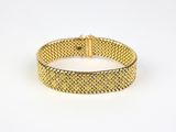 a gold mesh bracelet on a white background