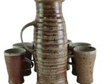 four cups and a pitcher sitting next to each other