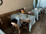 tables and chairs are set up in a restaurant with blue and white checkered tablecloths