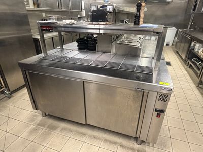 plan de travail en acier inoxydable dans une cuisine professionnelle équipée d'armoires en acier inoxydable