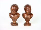 paire de bustes anciens en bois représentant des enfants, posés sur des socles