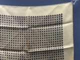 un gros plan d'un foulard carré blanc et noir sur fond bleu