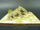 une statue représentant un éléphant et un homme dans un champ