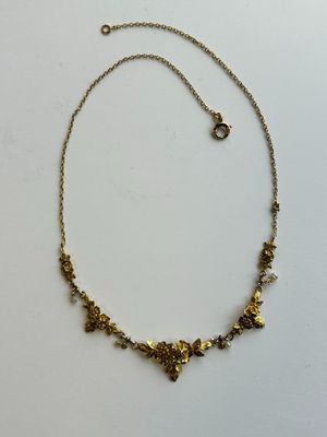 un collier en or orné de petites fleurs sur une chaîne