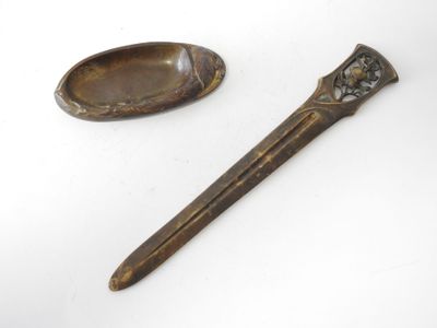 pair of antique spoons and spoon rest on a white surface
