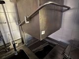 stainless steel sink and counter in a commercial kitchen with tiled walls