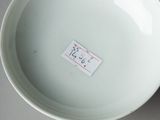 a white bowl sitting on a table with a sticker on it