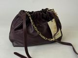 sac à main en cuir marron avec une bandoulière en chaîne dorée, sur fond blanc