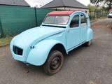 une petite voiture bleue garée sur le bord de la route