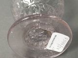 a glass vase with a label on it sitting on a table