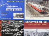 plusieurs livres posés sur une table, avec un train en arrière-plan
