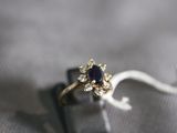 a ring with a sapphire and diamonds on it on a table