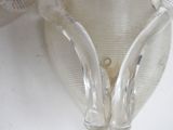 a glass vase that has two handles attached to it