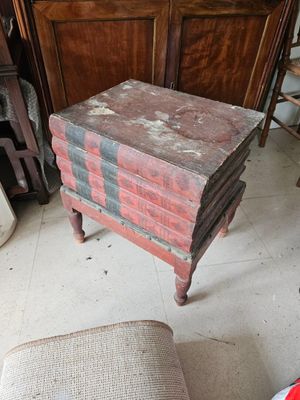 une pile de livres posée sur une chaise dans une pièce