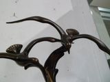 une statue en bronze représentant un oiseau perché sur une branche