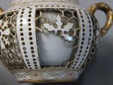 a white and gold vase sitting on a table