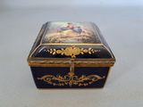 a black and gold box with a painting on it