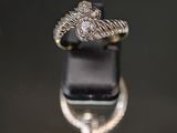 une image d'une bague en diamant sur une surface noire
