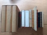 several books are stacked on top of each other on a wooden table
