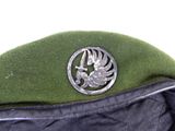 a green hat with a bird emblem on it