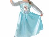 a little girl dressed in a frozen princess costume waving
