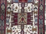 un vieux tapis orné d'un motif représentant des chevaux et des personnages