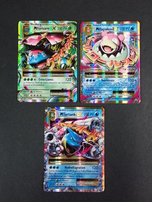 trois cartes Pokémon différentes posées sur une table avec un fond noir
