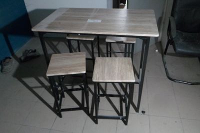 a table with four stools and a chair next to it
