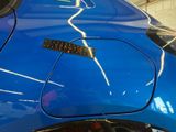 a close up of a blue car with a sticker on it
