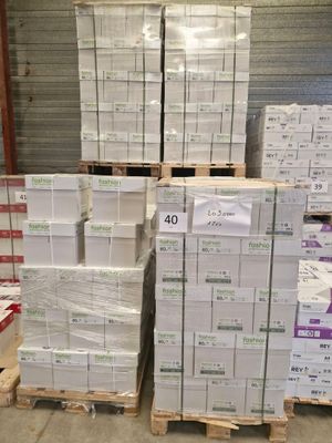 Plusieurs palettes de cartons sont empilées les unes sur les autres dans un entrepôt