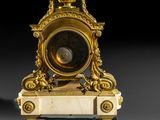 a gold clock sitting on top of a marble base